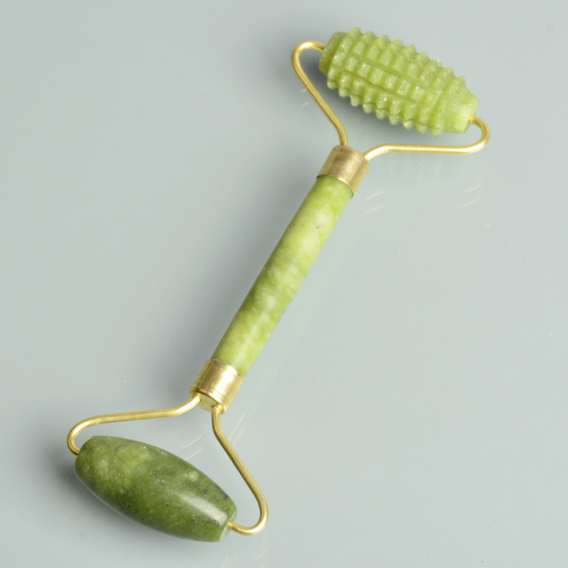 Green double-ended roller with textured and smooth heads on gray.