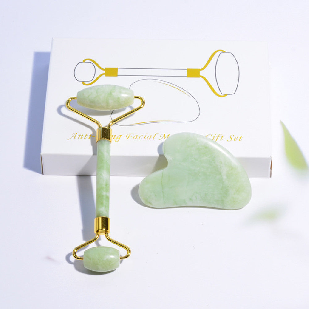 Double-ended green facial roller and matching gua sha tool with illustrated packaging.