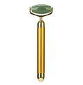 Gold electric facial roller with a green stone head.