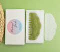 Green jade scalp massage comb in a white padded presentation box.